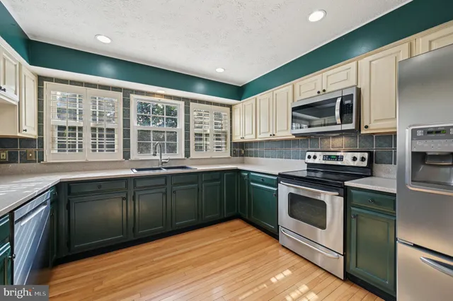 a kitchen with stainless steel appliances granite countertop a stove microwave and cabinets