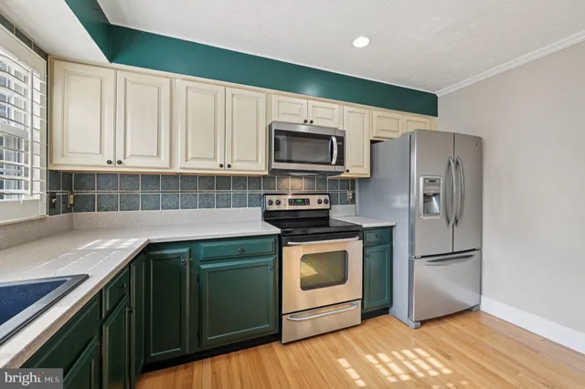 a kitchen with granite countertop a refrigerator stove and microwave