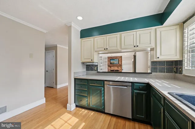 a kitchen with stainless steel appliances granite countertop a sink and cabinets with wooden floor