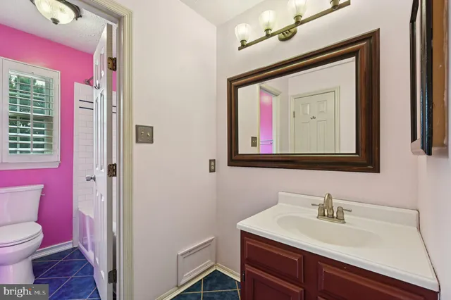 a bathroom with a toilet sink vanity and mirror