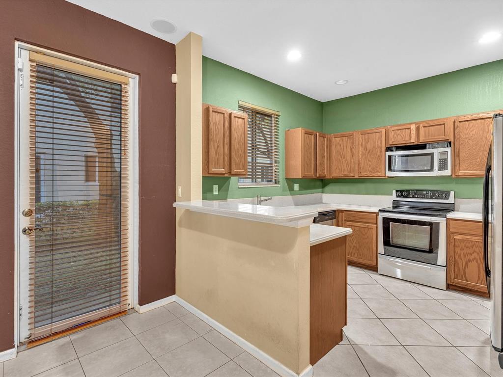 21421 Northwest 13th Court, Unit 211 Miami, FL 33169 - Photo 4 of 18 a kitchen with kitchen island granite countertop a stove top oven microwave and cabinets