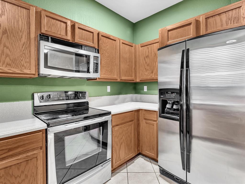 21421 Northwest 13th Court, Unit 211 Miami, FL 33169 - Photo 5 of 18 a kitchen with stainless steel appliances granite countertop a stove microwave and refrigerator