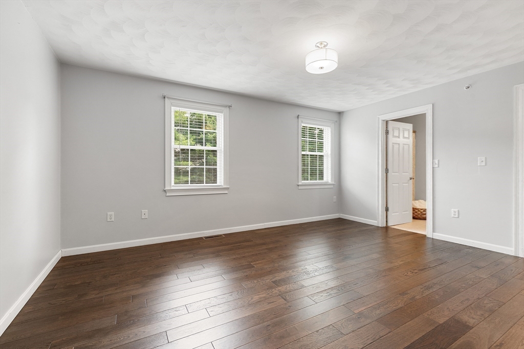2 Ricciuti Drive, Unit 9 Quincy, MA 02169 - Photo 22 of 40 an empty room with wooden floor and windows