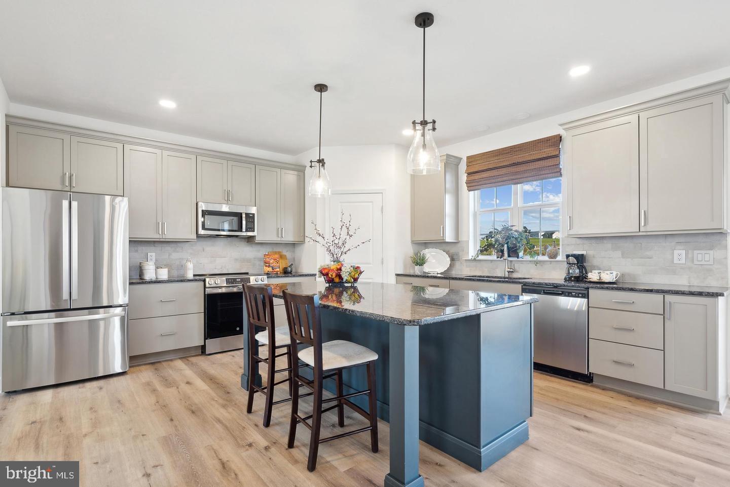 192 Ledger Drive, Unit 72 Hanover, PA 17331 - Photo 3 of 21 a kitchen with stainless steel appliances granite countertop a refrigerator a sink dishwasher a stove and white cabinets with wooden floor