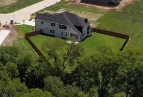 an aerial view of residential houses with outdoor space and trees