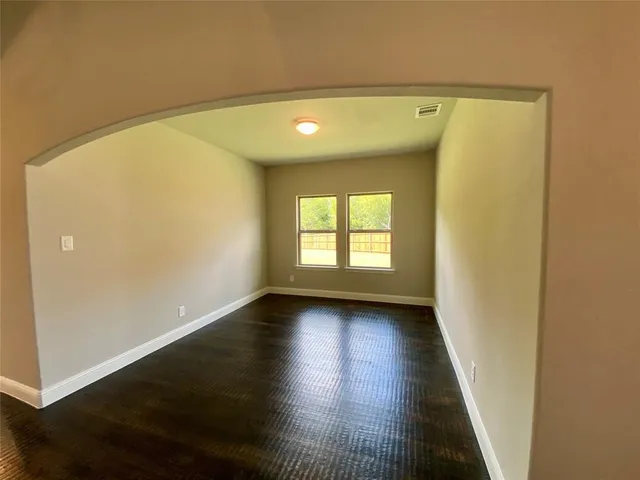 a view of a hallway with wooden floor and stairs