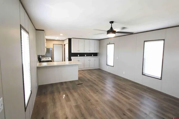 a kitchen with stainless steel appliances kitchen island hardwood floor sink and window