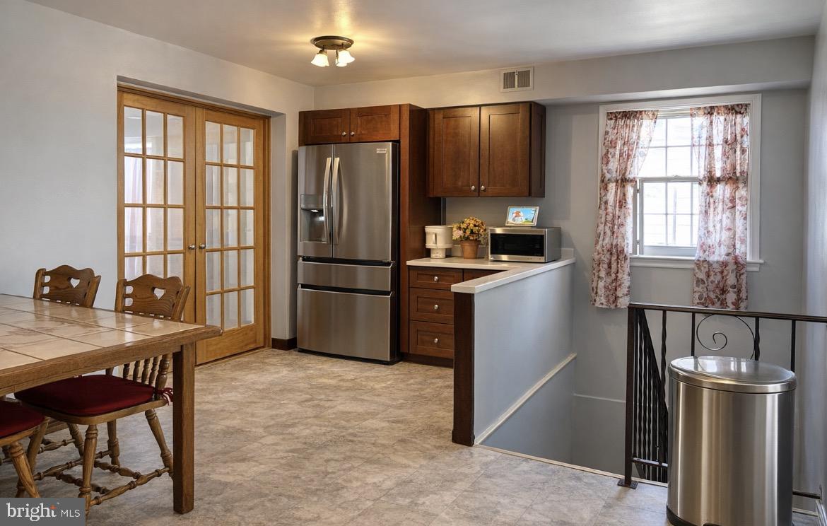 3243 Morrell Avenue Philadelphia, PA 19114 - Photo 6 of 28 a kitchen with stainless steel appliances granite countertop a refrigerator a stove a sink dishwasher a dining table and chairs with wooden floor