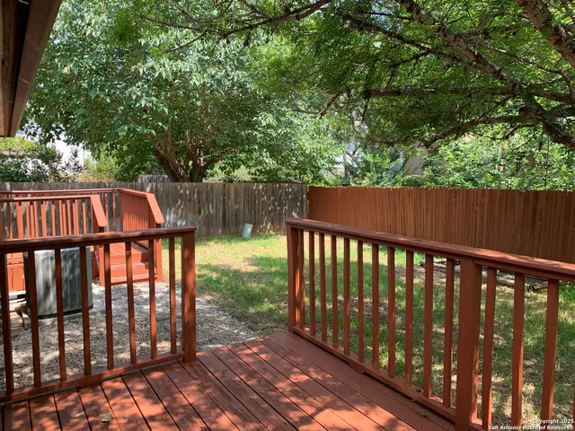 a view of deck with wooden fence and trees