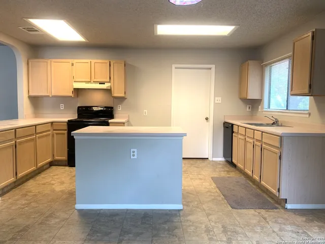 a kitchen with stainless steel appliances granite countertop a stove a sink a microwave a counter top space and cabinets