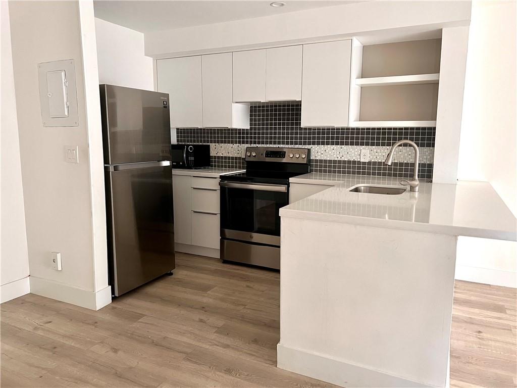 10930 Royal Palm Boulevard, Unit 10930 Coral Springs, FL 33065 - Photo 2 of 11 a kitchen with a refrigerator stove and microwave
