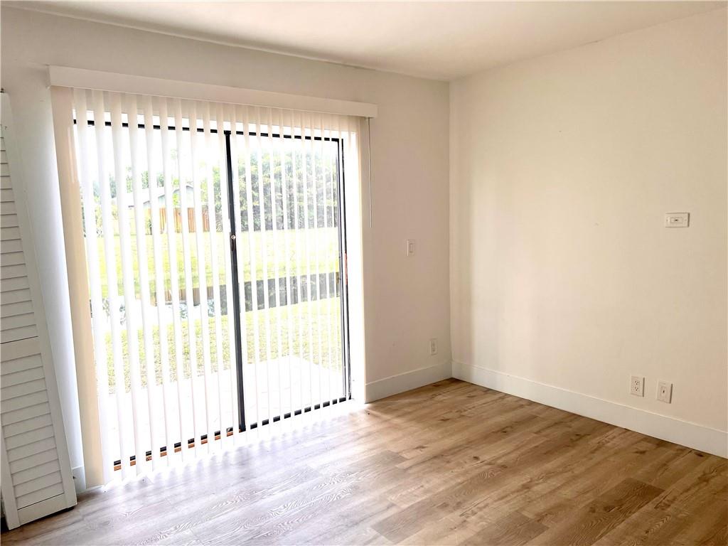 10930 Royal Palm Boulevard, Unit 10930 Coral Springs, FL 33065 - Photo 9 of 11 a view of an empty room with wooden floor and a window