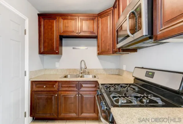 a kitchen with stainless steel appliances granite countertop a stove a sink and a refrigerator
