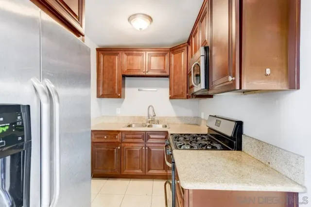 a kitchen with stainless steel appliances granite countertop a refrigerator and a stove