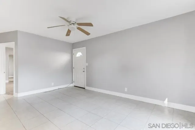 a view of an empty room and a ceiling fan