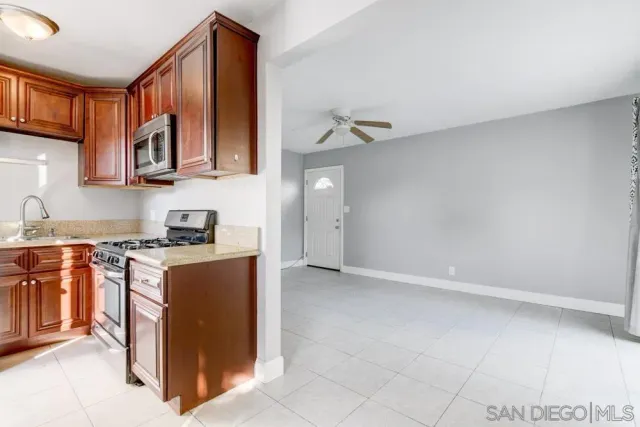 a kitchen with stainless steel appliances granite countertop a refrigerator a stove and a sink