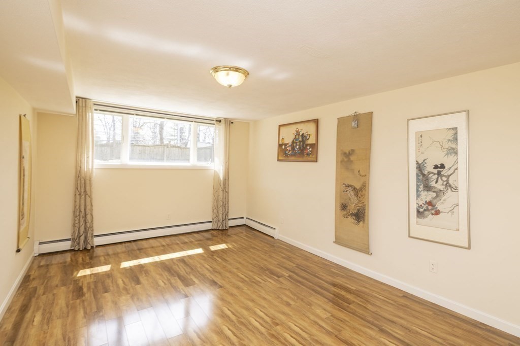 6 Nelson Drive Brookline, MA 02467 - Photo 27 of 42 a view of an empty room with window and wooden floor