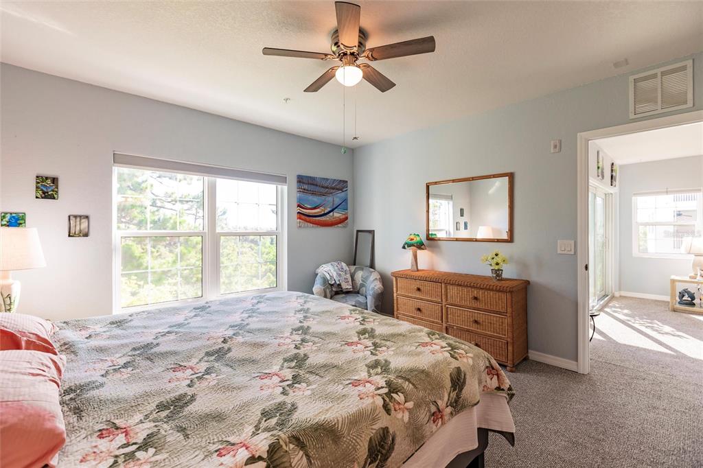 8409 Placida Road, Unit 308 Placida, FL 33946 - Photo 21 of 56 a bedroom with a large bed and a chandelier fan