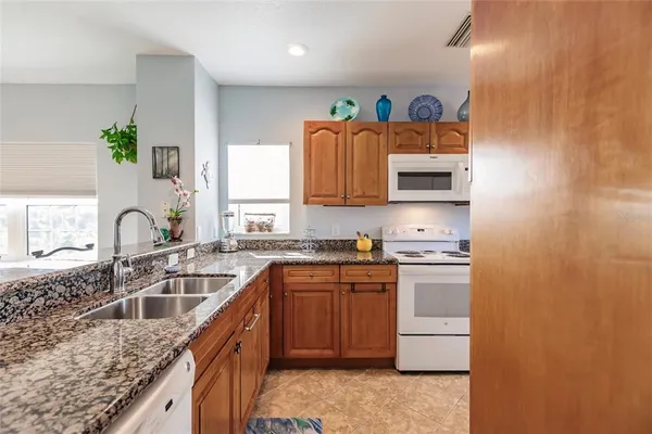 a kitchen with stainless steel appliances granite countertop a sink stove and cabinets
