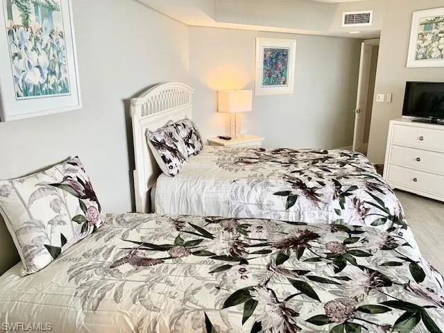 a bedroom with a bed and a tv on the dresser