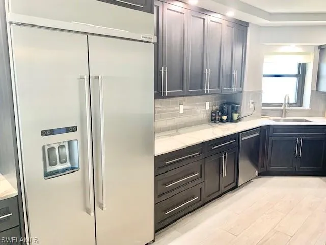 a kitchen with stainless steel appliances granite countertop a refrigerator and a sink