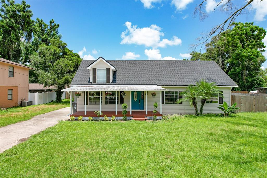 a view of a house with a yard and potted plants