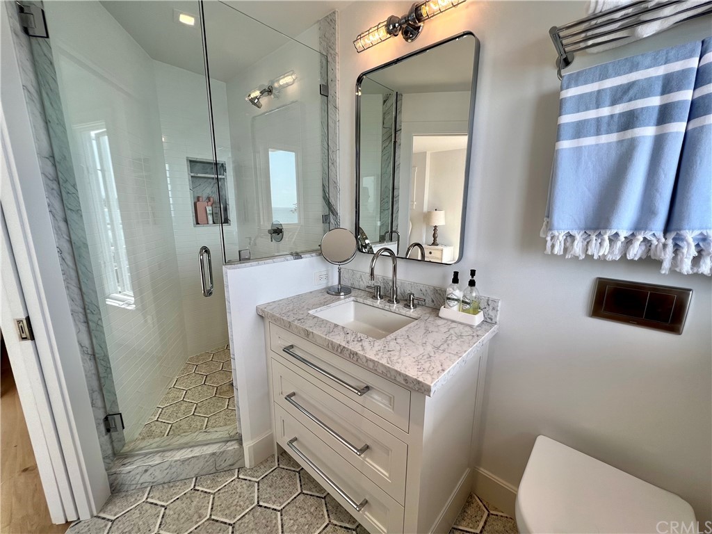 7 Camel Point Drive Laguna Beach, CA 92651 - Photo 39 of 48 a bathroom with a granite countertop sink a mirror a toilet and shower