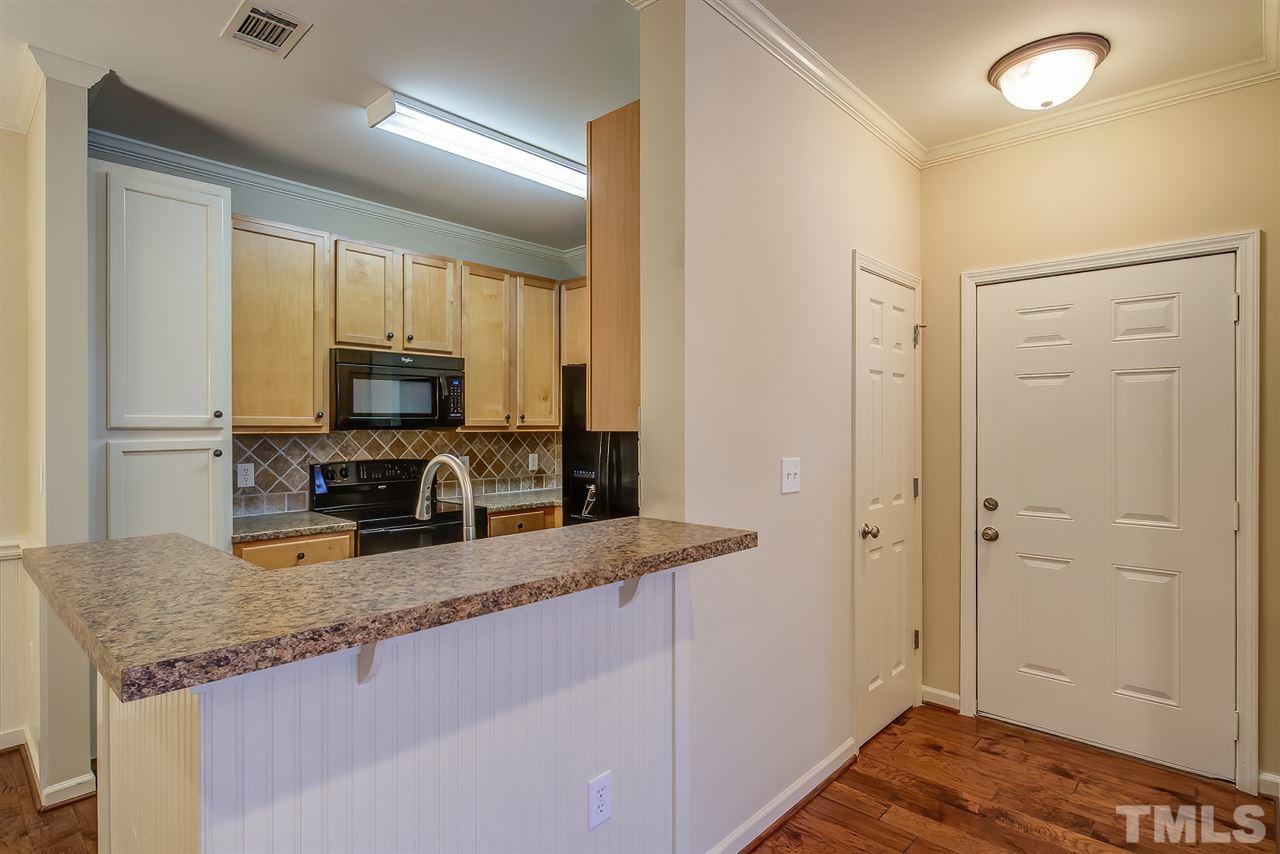 201 West Savannah Ridge Road, Unit 201 Holly Springs, NC 27540 - Photo 11 of 30 a kitchen with granite countertop a sink a stove cabinets and refrigerator