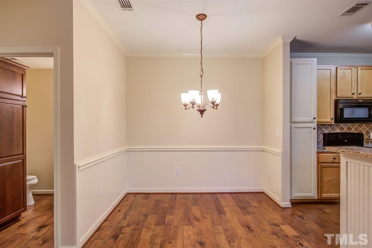 201 West Savannah Ridge Road, Unit 201 Holly Springs, NC 27540 - Photo 12 of 30 a view of empty room with wooden floor and kitchen