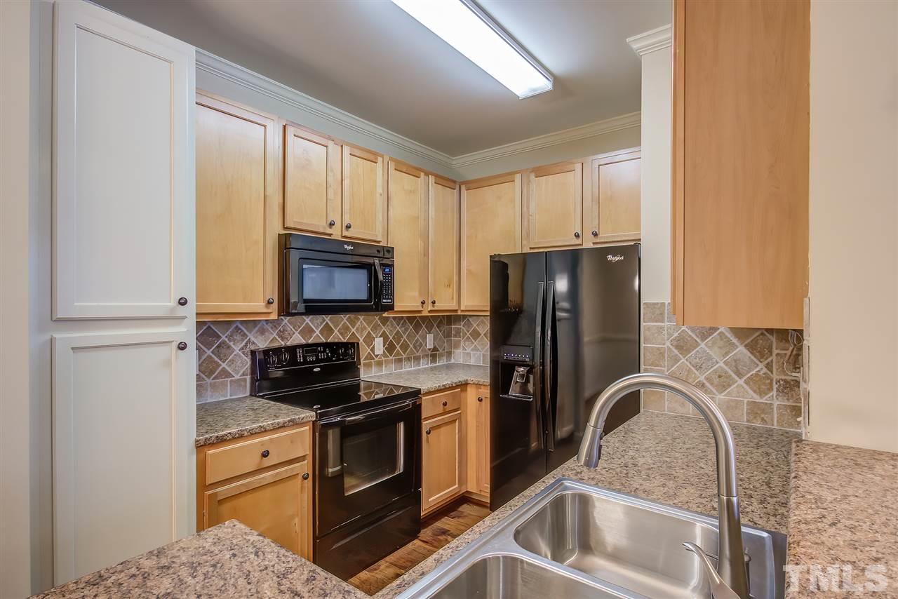 201 West Savannah Ridge Road, Unit 201 Holly Springs, NC 27540 - Photo 13 of 30 a kitchen with a refrigerator stove and sink