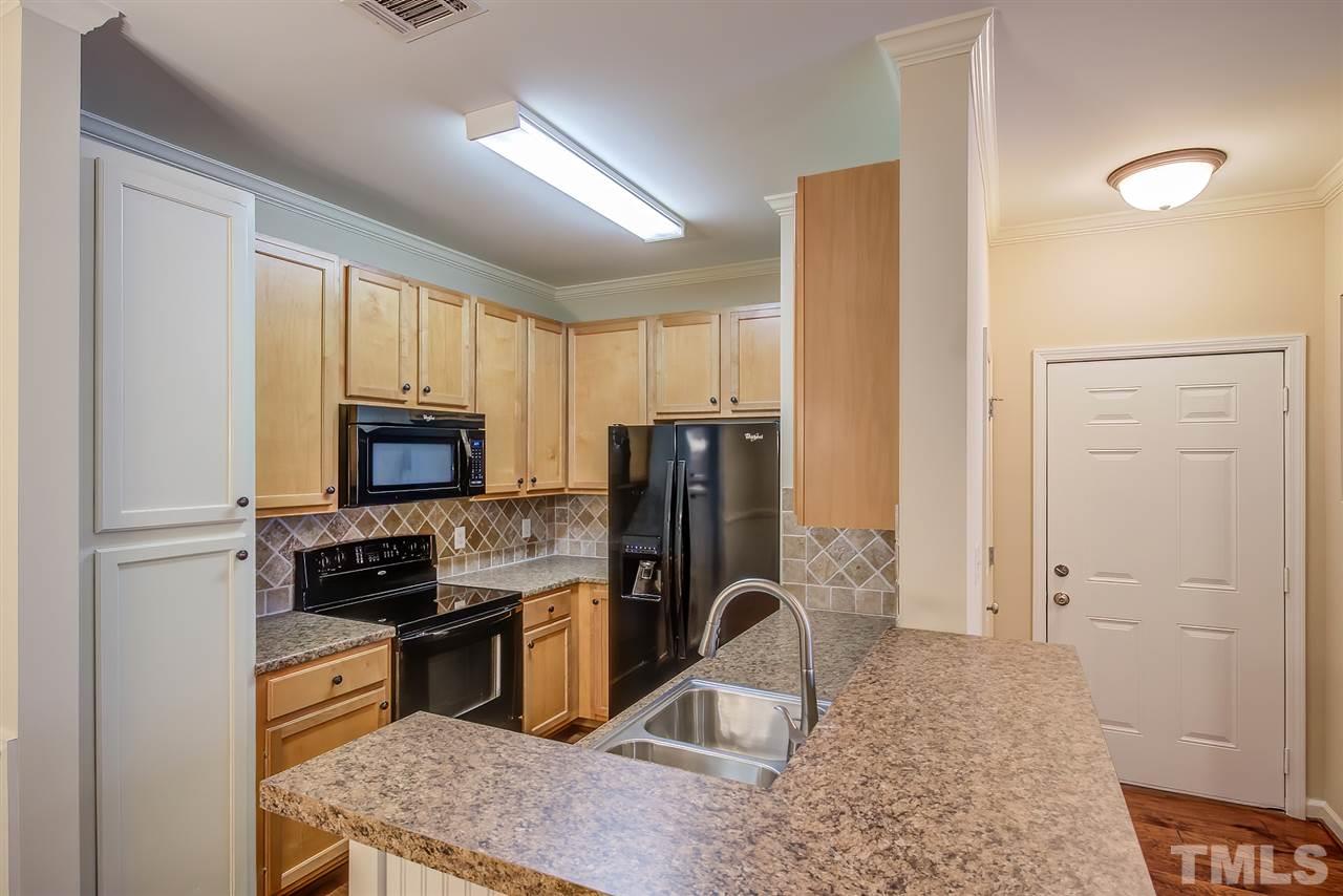 201 West Savannah Ridge Road, Unit 201 Holly Springs, NC 27540 - Photo 14 of 30 a kitchen with stainless steel appliances granite countertop a refrigerator stove top oven a sink and dishwasher