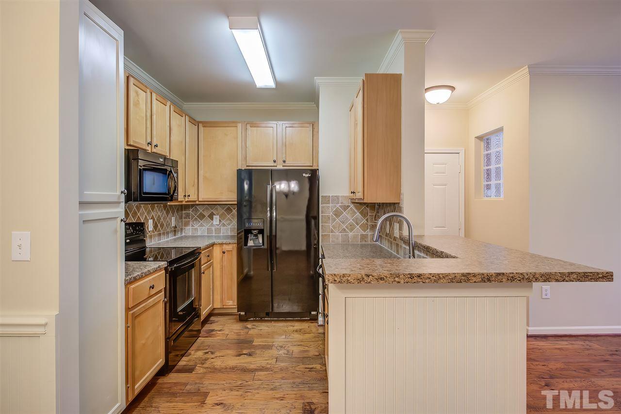 201 West Savannah Ridge Road, Unit 201 Holly Springs, NC 27540 - Photo 15 of 30 a kitchen with a refrigerator sink and stove top oven