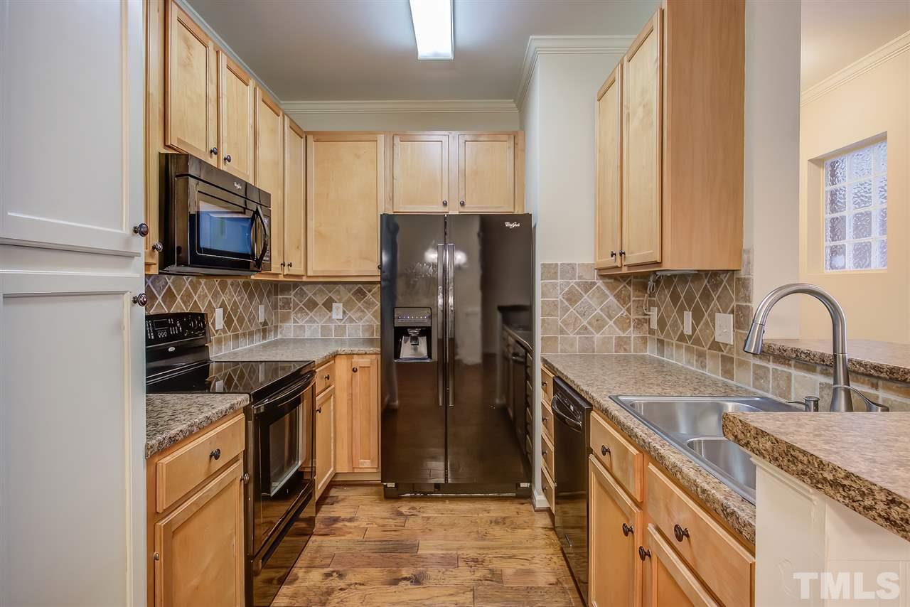201 West Savannah Ridge Road, Unit 201 Holly Springs, NC 27540 - Photo 16 of 30 a kitchen with stainless steel appliances granite countertop a stove refrigerator and a sink
