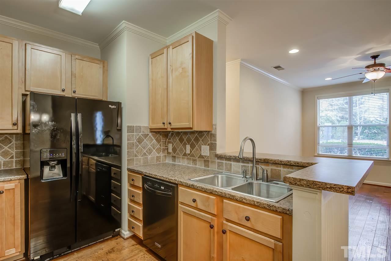 201 West Savannah Ridge Road, Unit 201 Holly Springs, NC 27540 - Photo 17 of 30 a kitchen with stainless steel appliances granite countertop a sink stove and refrigerator