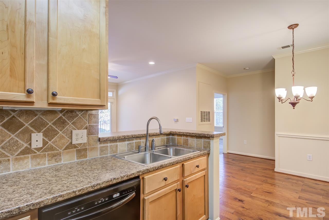 201 West Savannah Ridge Road, Unit 201 Holly Springs, NC 27540 - Photo 18 of 30 a kitchen with granite countertop a sink a stove and cabinets