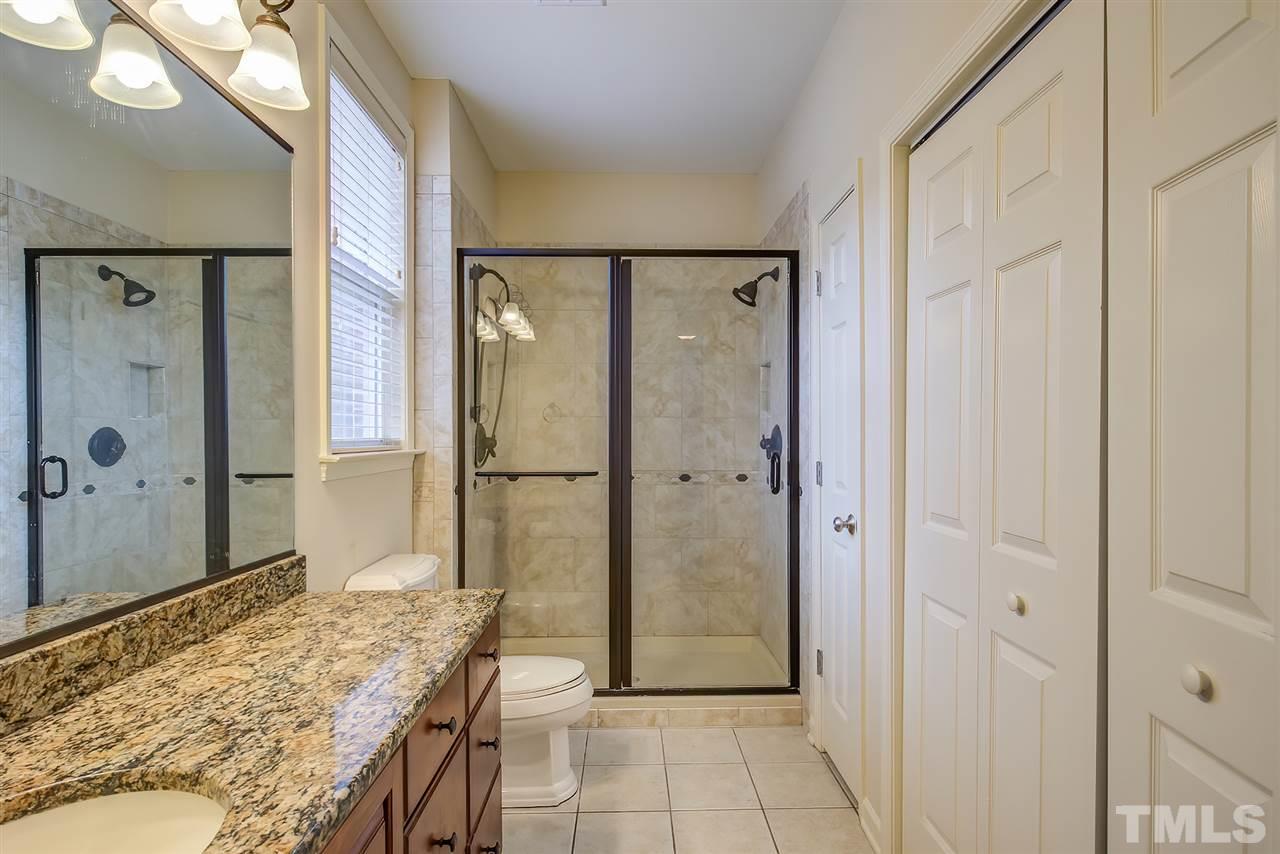 201 West Savannah Ridge Road, Unit 201 Holly Springs, NC 27540 - Photo 25 of 30 a bathroom with a granite countertop sink shower and a mirror