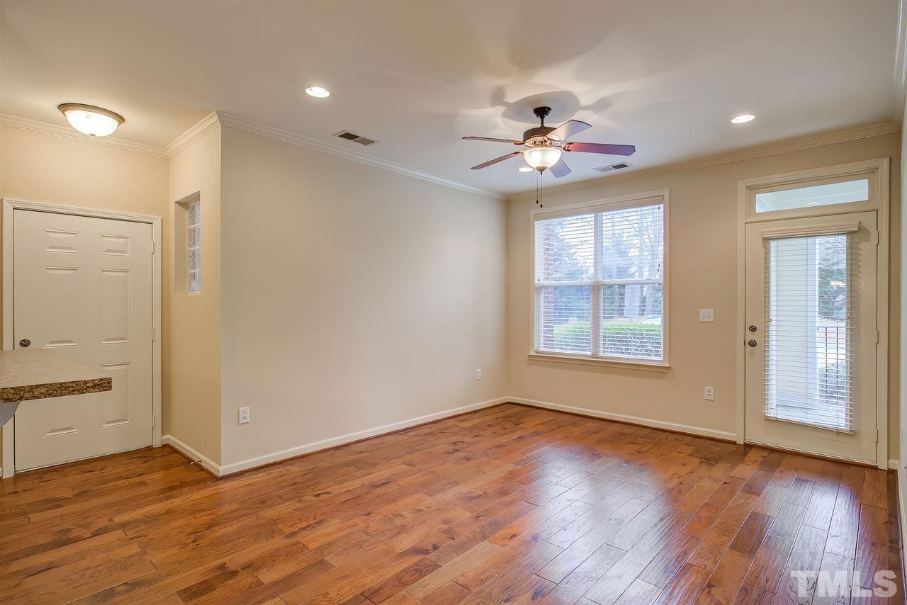 201 West Savannah Ridge Road, Unit 201 Holly Springs, NC 27540 - Photo 6 of 30 a view of an empty room with wooden floor and a window