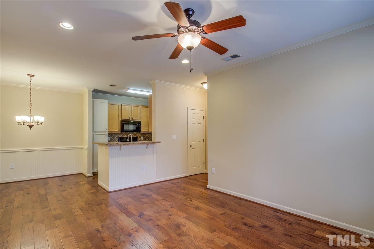 201 West Savannah Ridge Road, Unit 201 Holly Springs, NC 27540 - Photo 7 of 30 a view of an empty room and kitchen with ceiling fan