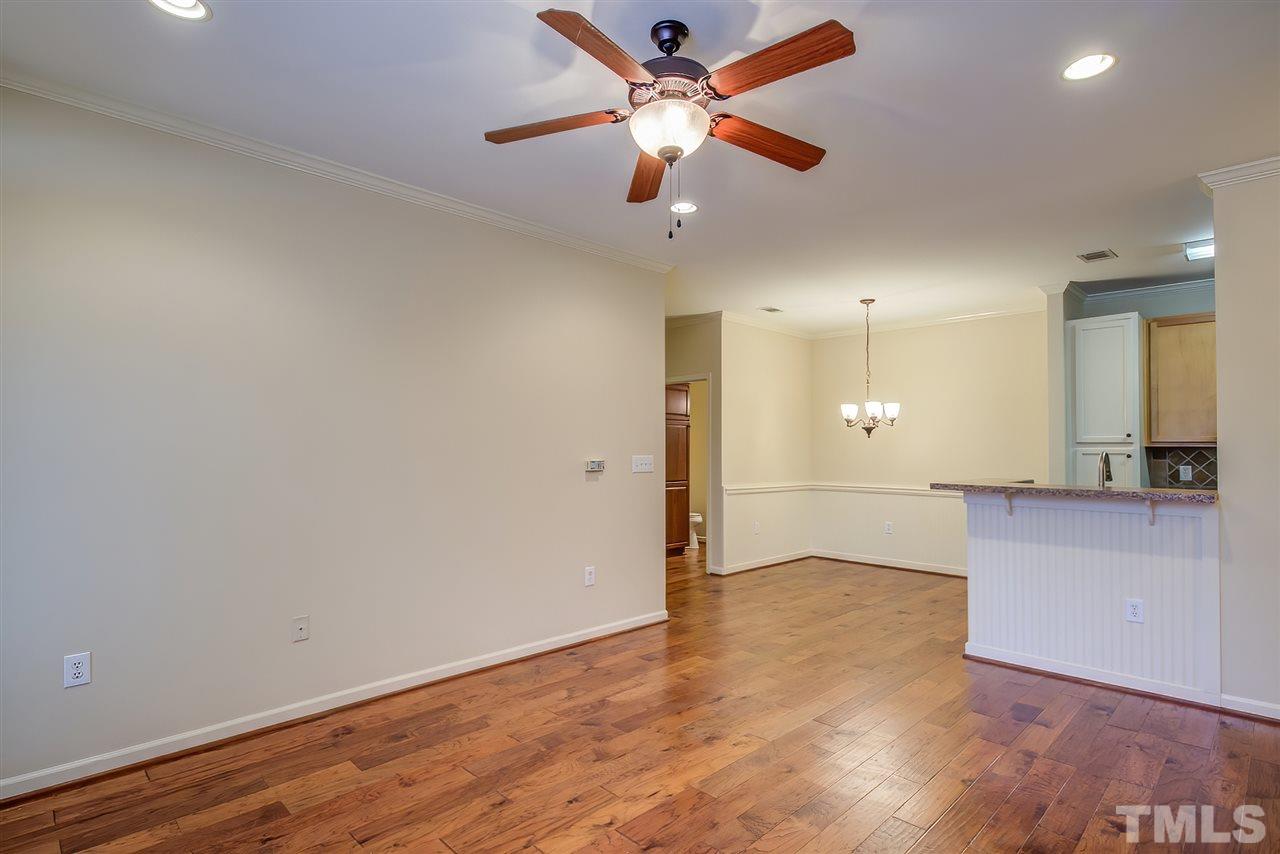 201 West Savannah Ridge Road, Unit 201 Holly Springs, NC 27540 - Photo 8 of 30 an empty room with wooden floor and a ceiling fan