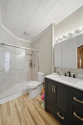 a bathroom with a sink a toilet and shower