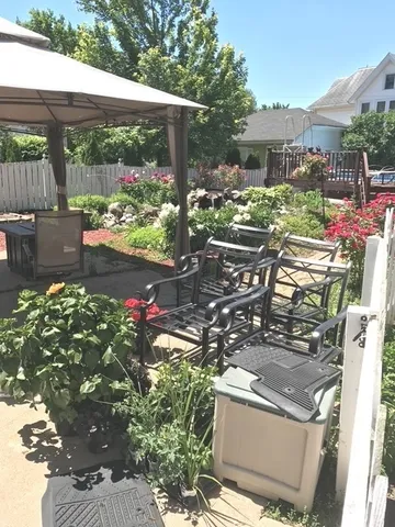a view of a patio with table and chairs potted plants