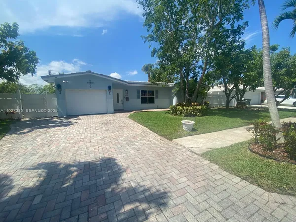 a view of a house with backyard and trees