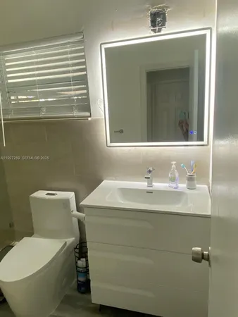 a bathroom with a toilet sink and mirror