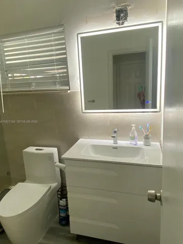 a bathroom with a toilet sink and mirror