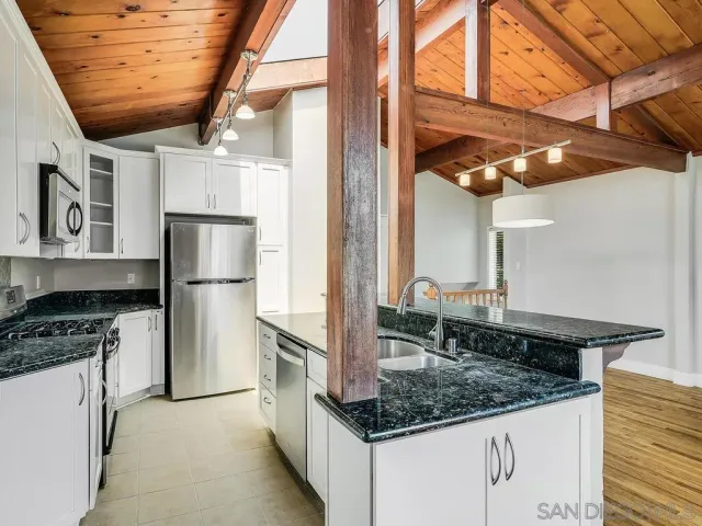 a kitchen with stainless steel appliances granite countertop a sink and a refrigerator