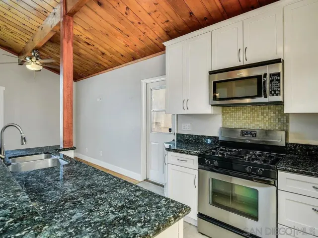 a kitchen with stainless steel appliances granite countertop a stove a microwave and a sink