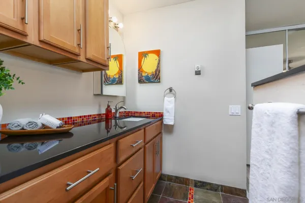 a bathroom with a granite countertop sink a toilet and a mirror