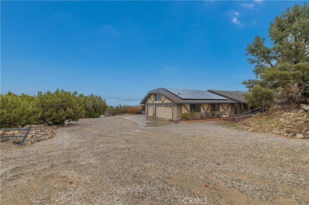 9539 Soledad Road Pinon Hills, CA 92372 - Photo 13 of 66 a front view of a house with a yard and garage