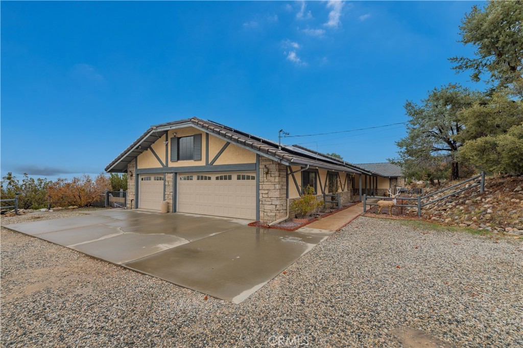 9539 Soledad Road Pinon Hills, CA 92372 - Photo 14 of 66 a front view of a house with a yard and garage