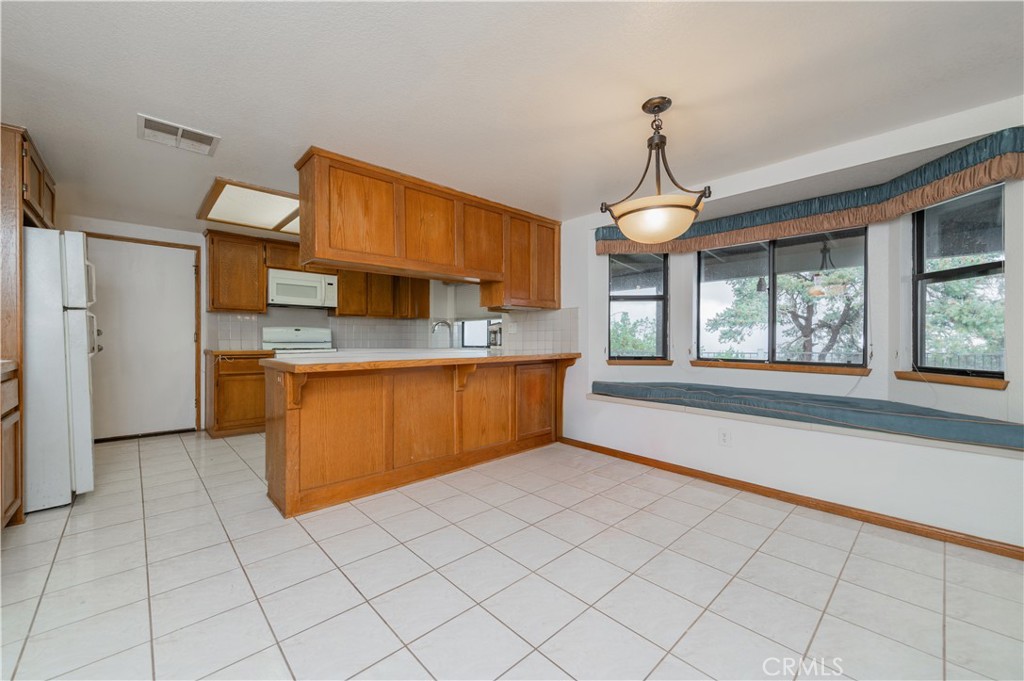9539 Soledad Road Pinon Hills, CA 92372 - Photo 27 of 66 a kitchen with stainless steel appliances granite countertop a stove a sink dishwasher and a view of living room